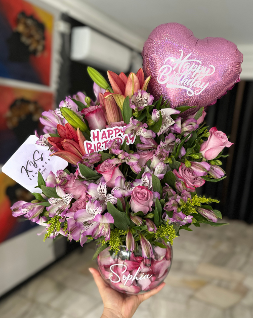 arreglo floral en base de vidrio con rosas y lirios