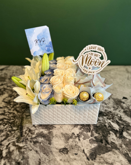 elegante arreglo de rosas y lirios con tonos azul, chocolates